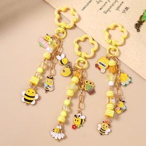 Trois porte-clés thème abeille avec fleurs jaunes, pots de miel et pendentifs tournesol
