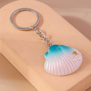 Detail view of shell keychain with pink blue gradient finish and small pearl accents