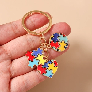 Dettaglio portachiavi puzzle a cuore con ciondoli in smalto vivace su anello dorato