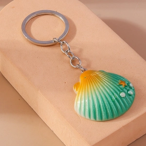 Detail of seashell keychain with yellow-green gradient resin and pearl accents
