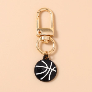 Detail view of a gold basketball keychain with black enamel finish and lobster clasp