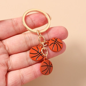 Détail d'un porte-clés doré en alliage avec trois pendentifs de basket-ball orange