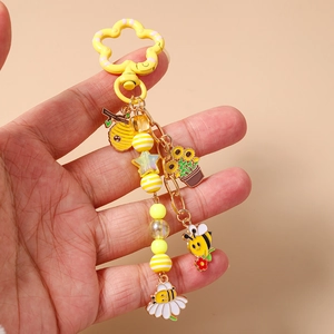 Porte-clés perlé à la mode avec abeille et tournesol et pendentifs nid d'abeille sur main