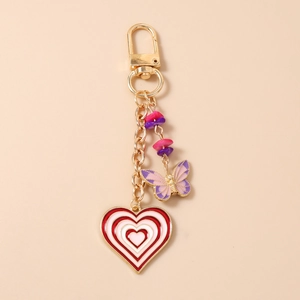 Detailed view of a gold-plated keychain with red heart charms and purple butterfly pendants