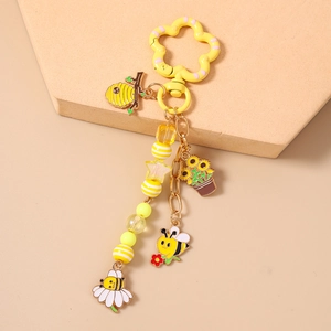 Détail du porte-clés abeille avec crochet fleur jaune et breloques en perles colorées