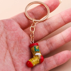 Close-up of glittery Christmas stocking keychain with gold hardware and festive patterns