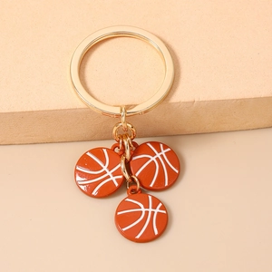 Détail de trois pendentifs de basket-ball sur un porte-clés en métal doré poli