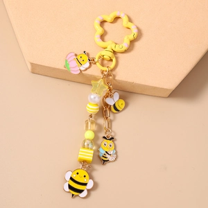 Détail du porte-clés abeille avec breloques en émail jaune et chaîne de perles