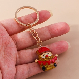 Detail of Christmas Santa keychain with golden metal ring and sparkling resin finish