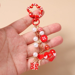 Detailed close-up of a red Be Lovely beaded heart keychain with white pearls and heart charms