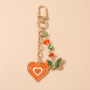 Close-up of golden alloy keychain featuring butterfly charm and heart pendant with beads