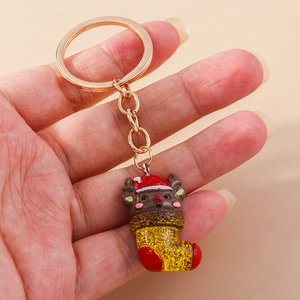 Close-up of a Christmas elk inside a red stocking keychain with golden glitter and hardware