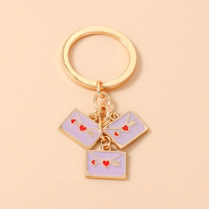 Detail of lavender envelope charms with red heart and gold arrow on a keyring