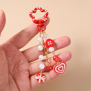 Detailed close-up of a red heart keychain with Kiss Me lips and pearl bead charms