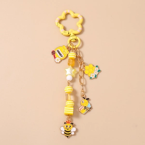 Détail d'un joli porte-clés abeille avec breloque pot de miel et fermoir fleur