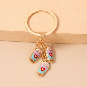 Macro detail of three layered colorful milk tea pendants with red hearts on a gold keychain
