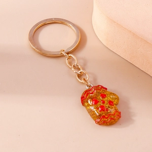 Detail of yellow resin glove keychain with red stars on smooth peach background