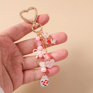 Close-up of pink beaded keychain with heart pendant, love charms and a mini jar