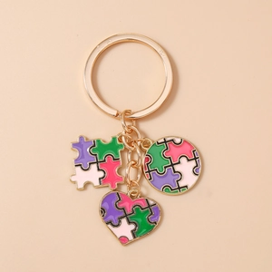Dettaglio del portachiavi puzzle a cuore geometrico con smalto colorato e anello dorato