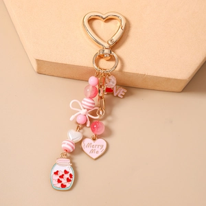 Close-up of pink beaded keychain with heart charms and a love bottle on a soft background