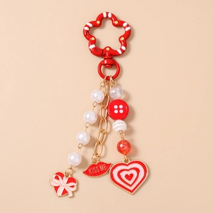 Detail of red kiss me lip charm and white pearl beads on a fashionable heart keychain
