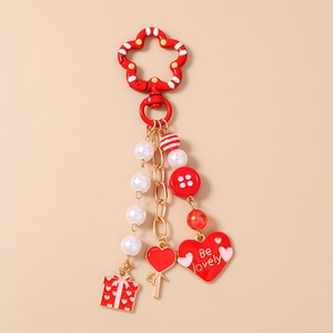 Detailed view of a red heart keychain with Be Lovely charm and striped beads