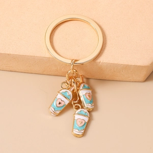 Close-up of golden keychain with three colorful heart-patterned milk tea cup charms