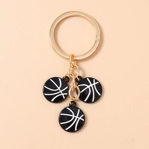 Vue détaillée du porte-clés basketball doré avec pendentifs en émail noir et blanc