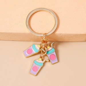 Close-up of golden keychain with three colorful milk tea charms in pink and blue