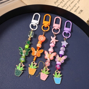 Détail de porte-clés colorés à perles avec papillon et cactus sur plateau bleu
