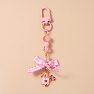 Detailed shot of pink beaded keychain featuring ribbon bow and heart handbag charms