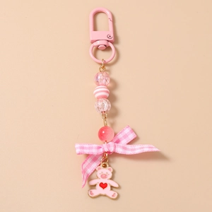 Detail of pink beaded keychain with checkered bow and cute heart bear enamel charm