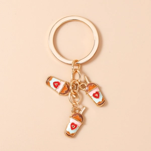 Close-up of cute enamel milk tea charms with heart motifs on a gold keychain ring