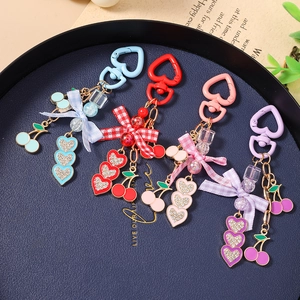 Set of four colorful cherry bow keychains with heart buckles and sparkling crystals