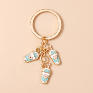 Detail of three blue milk tea charms with pink hearts on a gold-plated metal keychain