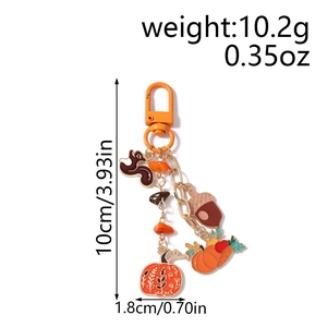 Detail view of squirrel and pumpkin enamel keychain with dimensions and weight display