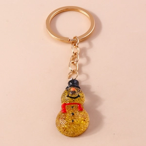 Christmas snowman keychain with gold glitter resin and red scarf on pink background