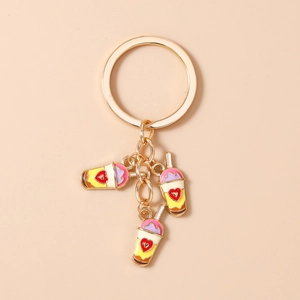 Detailed close-up of heart-pattern milk tea cup pendants on a golden keychain ring