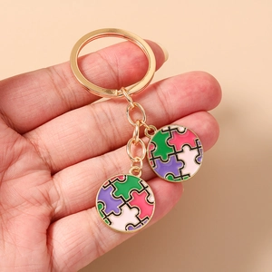 Détail de pendentifs en émail à motif de puzzle coloré sur un porte-clés doré