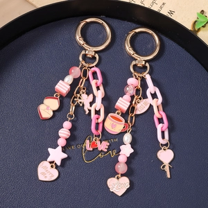 Pink beaded star keychain with LOVE heart charms and acrylic chain on dark tray