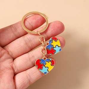 Détail de pendentifs puzzle en cœur doré sur un porte-clés avec couleurs en émail vif