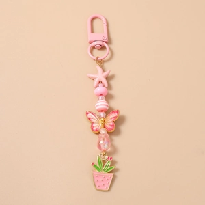 Vue détaillée du porte-clés rose perlé avec pendentifs étoile de mer et papillon