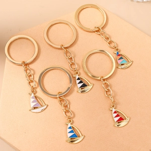 Set of five creative alloy sailboat keychains with colorful enamel pendants and golden finish