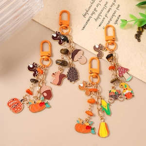 Harvest-themed keychain collection with squirrel, pumpkin, and acorn charms in gold finish