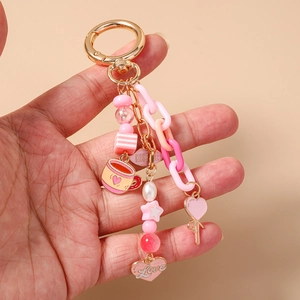 Detailed view of handmade pink beaded keychain with heart charms and gold metal ring