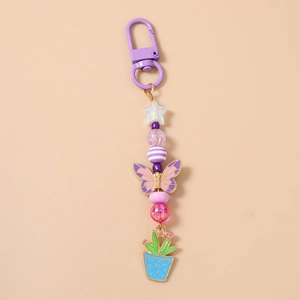 Détail du porte-clés perlé avec breloque papillon et pendentif cactus en émail violet