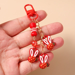 Portachiavi con coniglio fragola alla moda con perle rosse e catena in metallo dorato