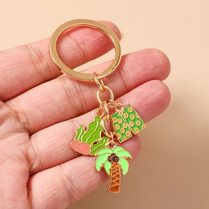 Detail of tropical keychain with enamel cactus, coconut tree, and floral swim trunks charm