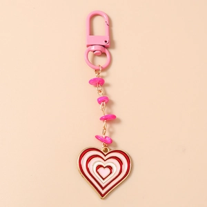 Vue détaillée du porte-clés en forme de cœur avec perles roses et pendentif émaillé
