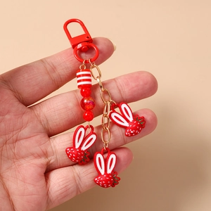 Dettaglio portachiavi a forma di coniglio fragola con perline rosse e ciondoli in resina